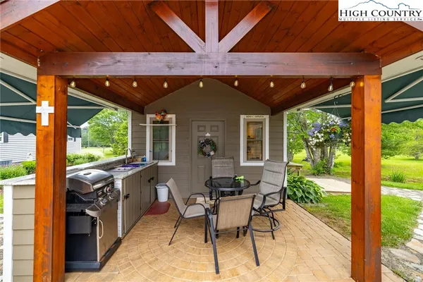 a patio with table and chairs and potted plants