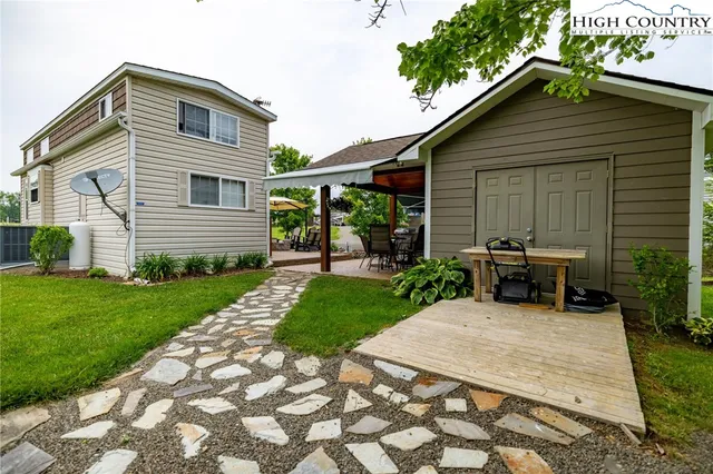 a backyard of a house with table and chairs