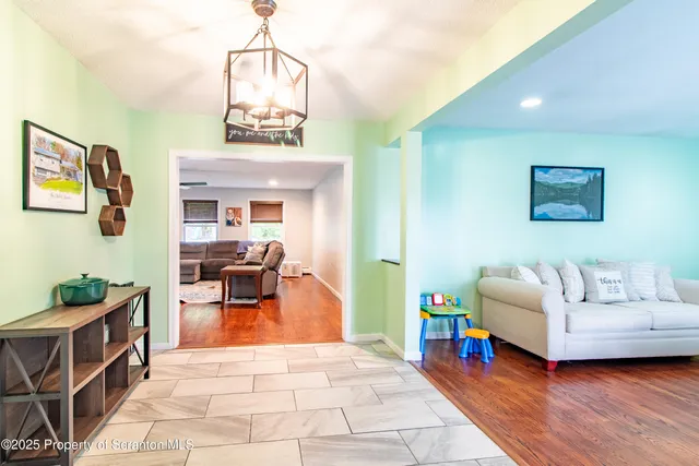 a living room with furniture a flat screen tv and a floor to ceiling window