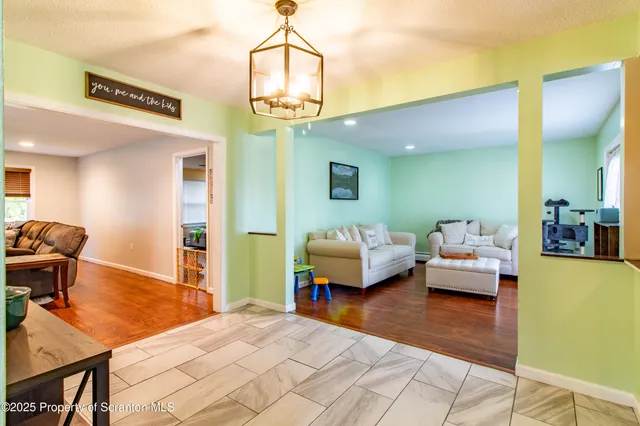 a living room with furniture and a flat screen tv with wooden floor