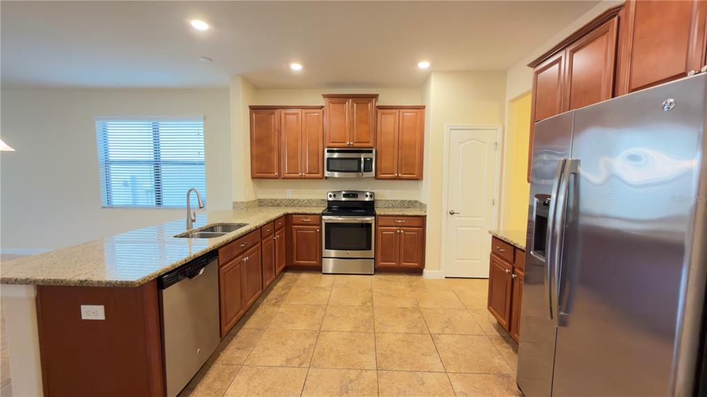 13040 Overstreet Road Windermere, FL 34786 - Photo 11 of 45 a large kitchen with stainless steel appliances granite countertop a stove a sink and a refrigerator
