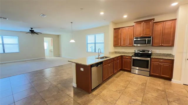 a kitchen with stainless steel appliances granite countertop a stove top oven a sink a counter top space and cabinets