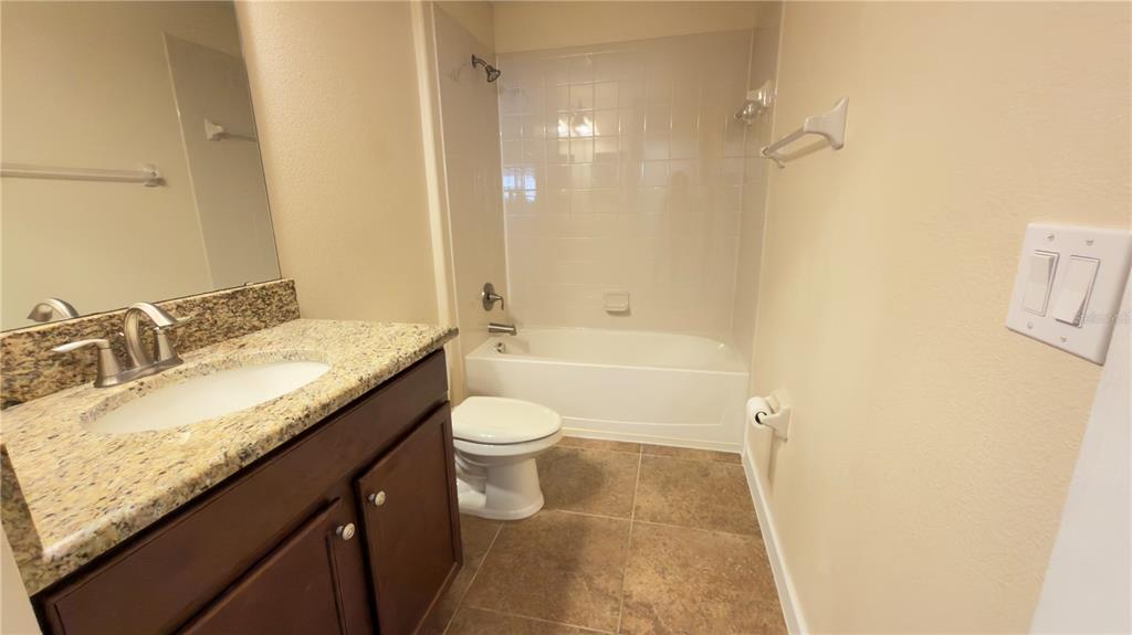 13040 Overstreet Road Windermere, FL 34786 - Photo 25 of 45 a bathroom with a granite countertop sink a toilet and shower