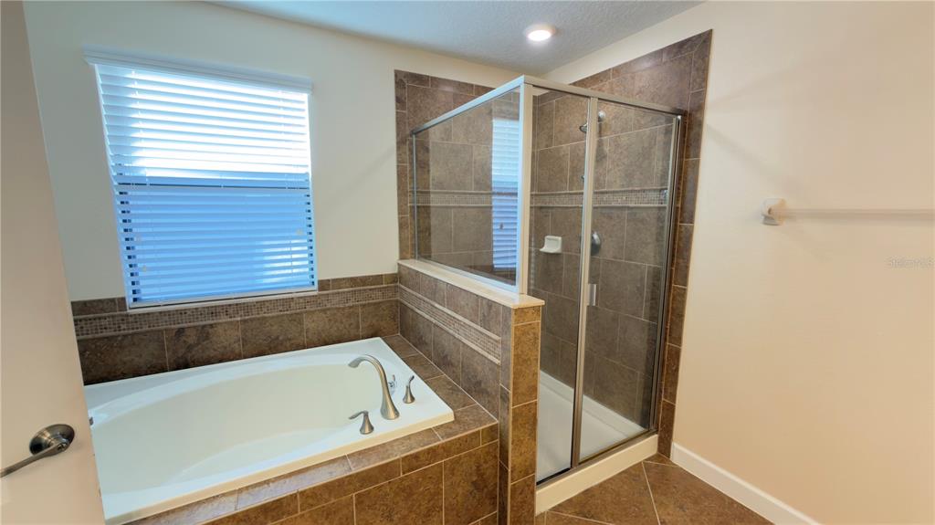 13040 Overstreet Road Windermere, FL 34786 - Photo 31 of 45 a bathroom with a bathtub and a shower