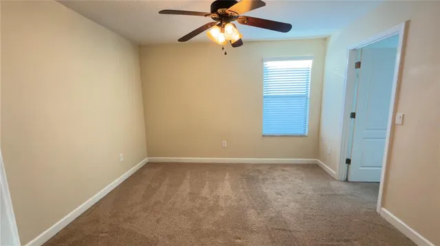 an empty room with closet and a chandelier fan