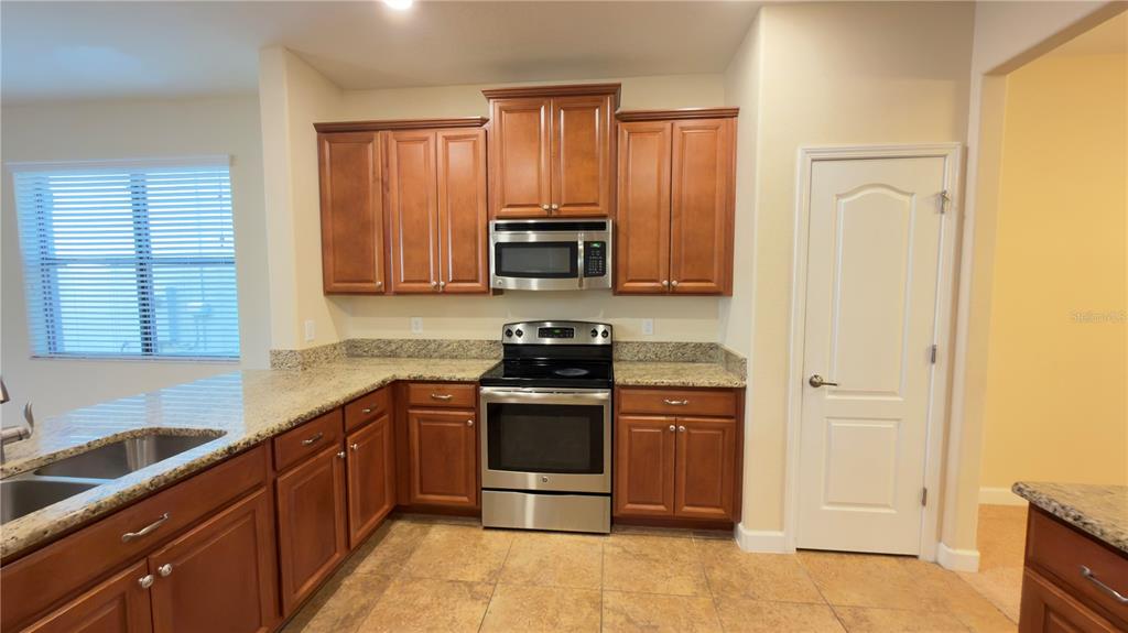 13040 Overstreet Road Windermere, FL 34786 - Photo 10 of 45 a kitchen with stainless steel appliances granite countertop a stove and a refrigerator