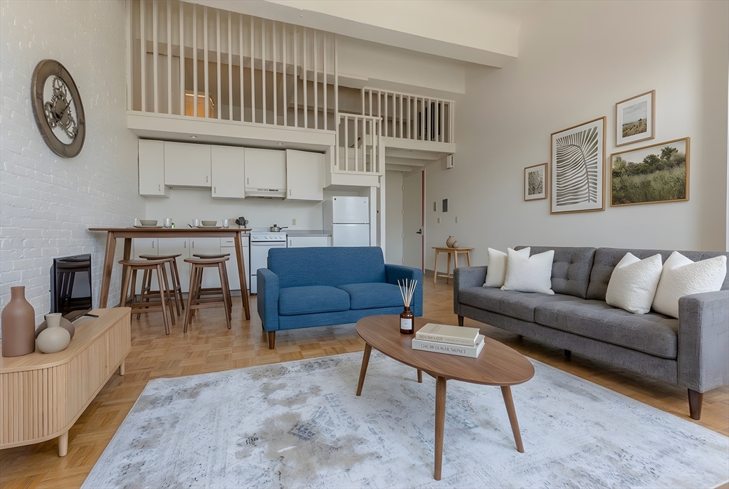 a living room with furniture a rug and a wall painting