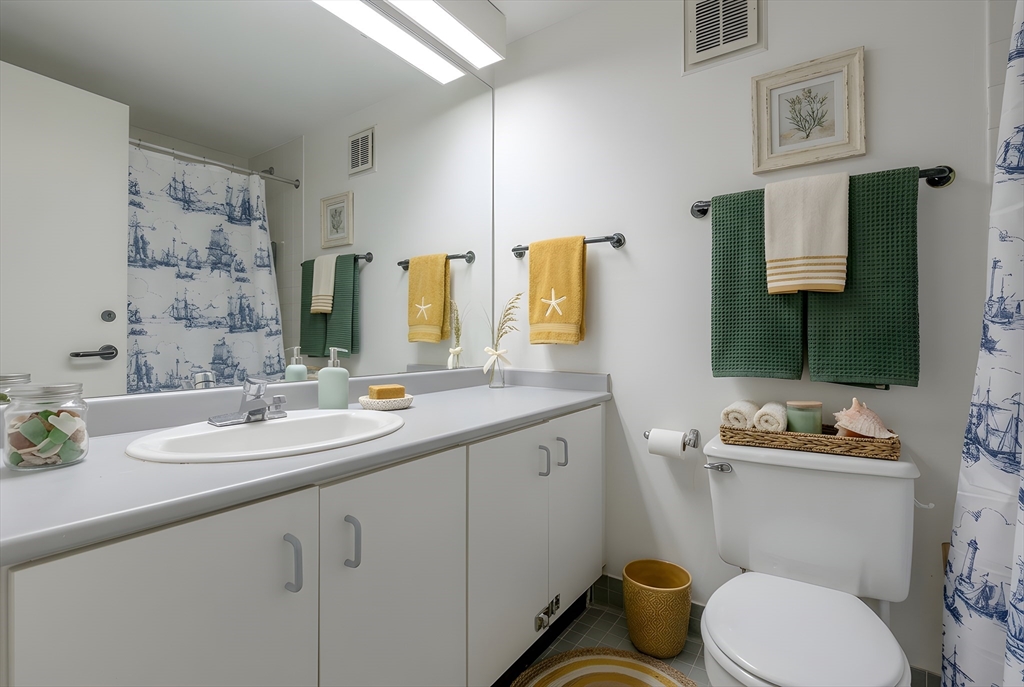 61 Brookline Avenue, Unit 214 Boston, MA 02215 - Photo 4 of 7 a bathroom with a granite countertop toilet sink and mirror