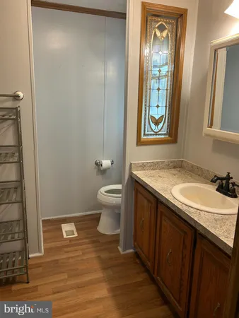a bathroom with a granite countertop sink toilet and mirror