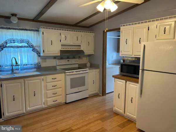 a kitchen with white cabinets and white appliances