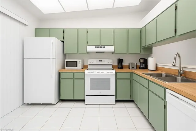 a kitchen with a refrigerator sink and cabinets