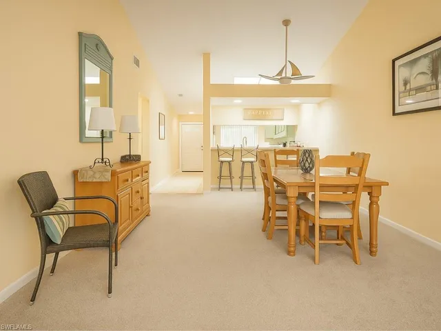 a dining room with furniture and a floor to ceiling window