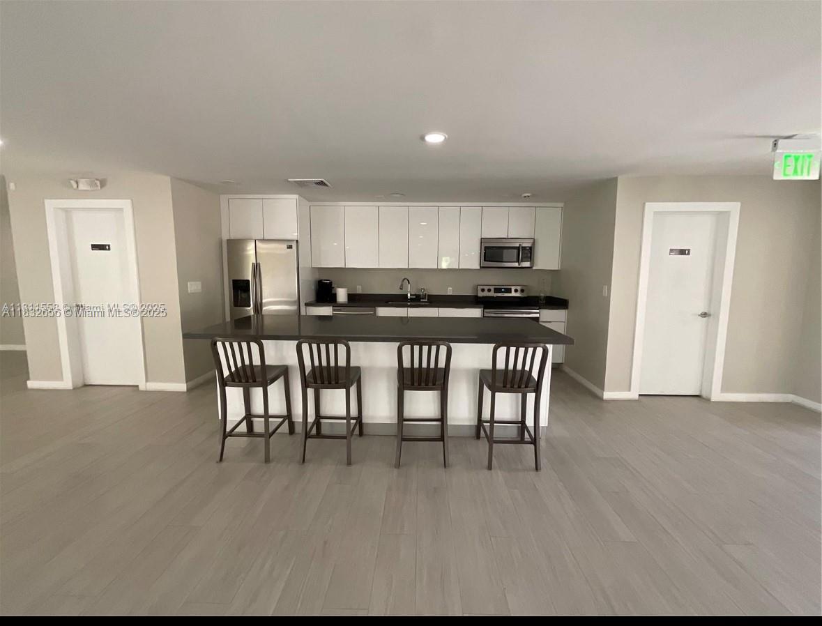 Kendall Miami, FL 33173 - Photo 13 of 20 a kitchen with stainless steel appliances a table and chairs in it