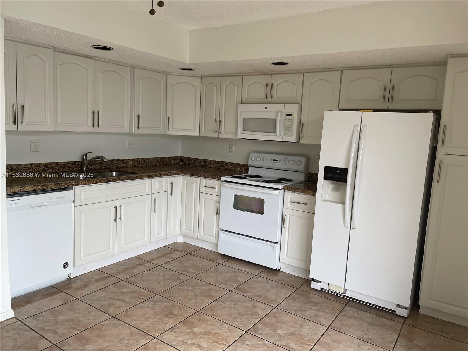 Kendall Miami, FL 33173 - Photo 4 of 20 a kitchen with white cabinets and white appliances