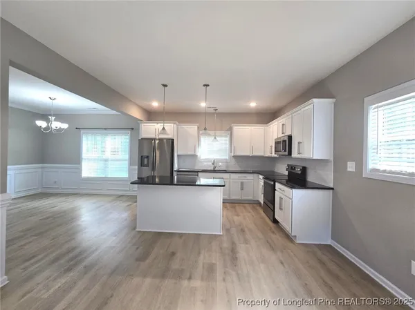 a large kitchen with cabinets wooden floor and stainless steel appliances