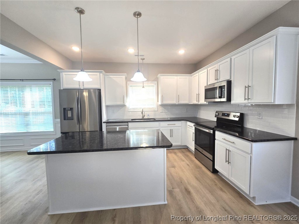 7018 Summerlin Drive Fayetteville, NC 28306 - Photo 14 of 39 a large kitchen with granite countertop a stove a sink a refrigerator and a microwave