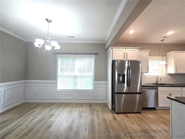 a kitchen with kitchen island a counter top space wooden floor and stainless steel appliances