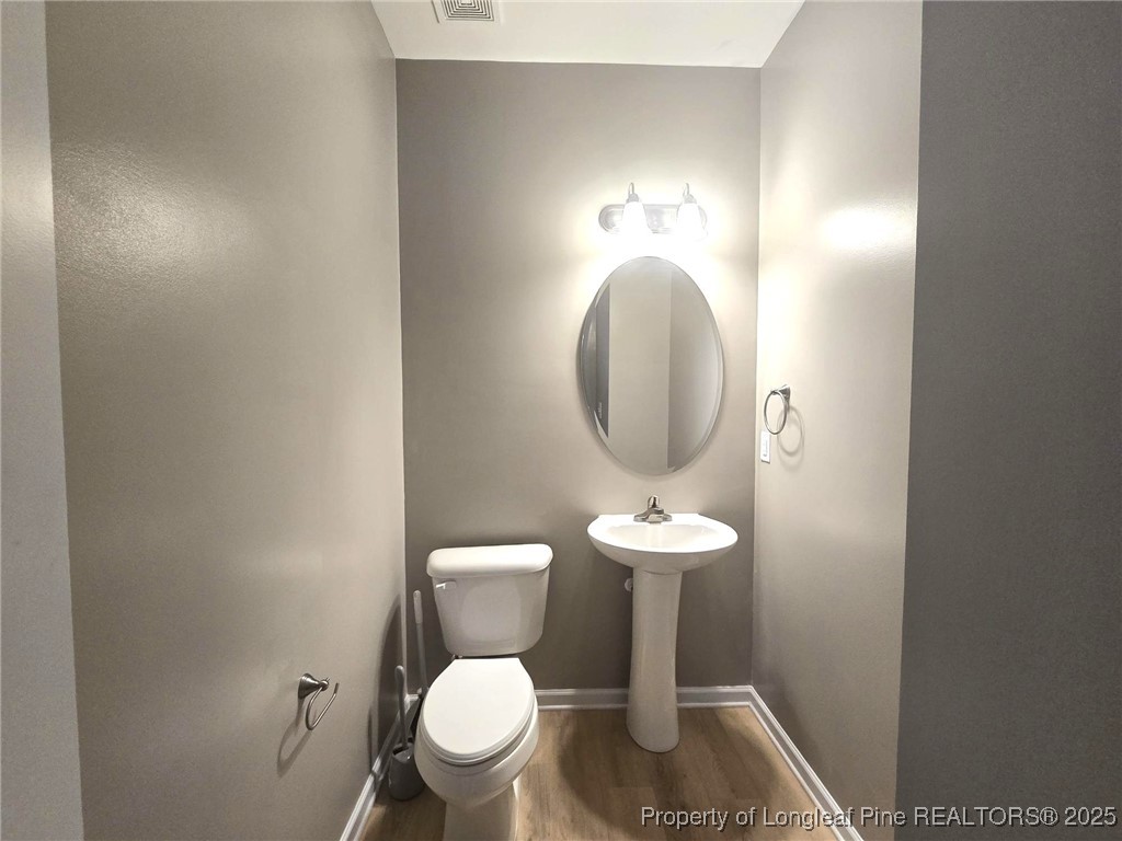 7018 Summerlin Drive Fayetteville, NC 28306 - Photo 19 of 39 a bathroom with a toilet a sink and a mirror