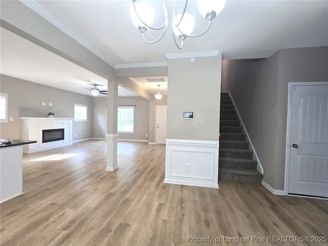 a view of a hallway with wooden floor and staircase