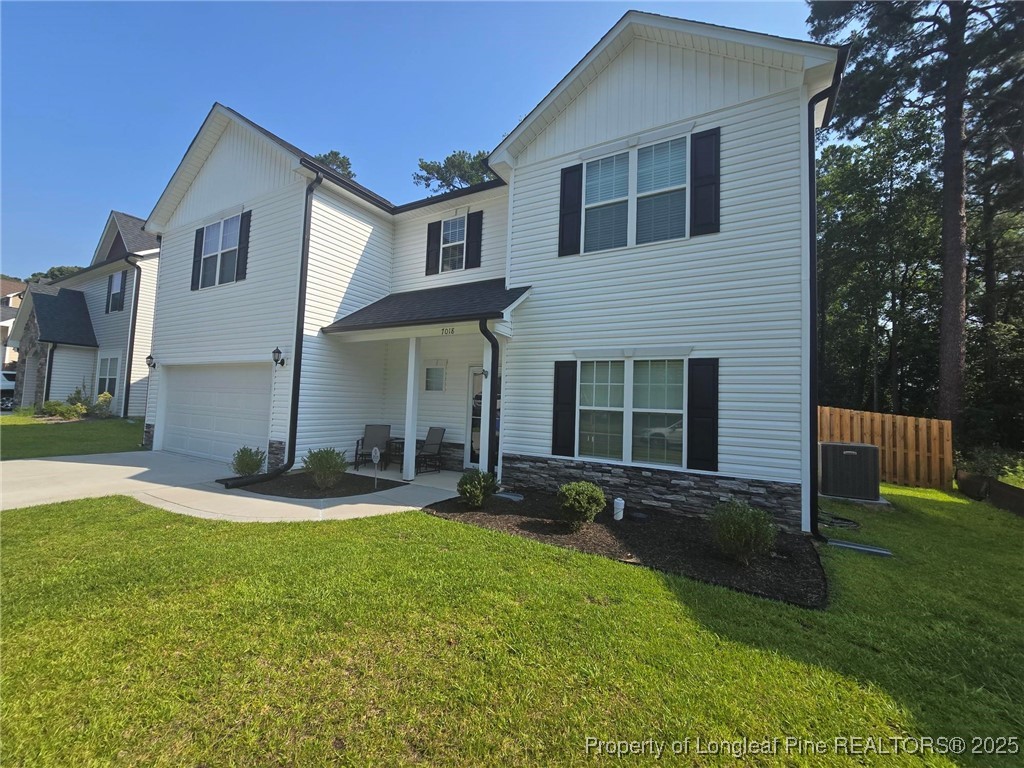 7018 Summerlin Drive Fayetteville, NC 28306 - Photo 4 of 39 a front view of a house with a yard and garage