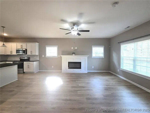 a view of a kitchen with a stove a kitchen island with wooden floor and a window