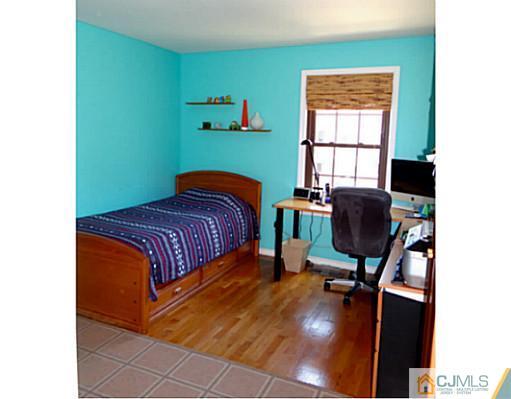 3403 Springbrook Drive Edison, NJ 08820 - Photo 17 of 24 a bedroom with a bed a table and a window