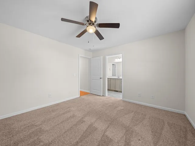 a view of an empty room and chandelier fan