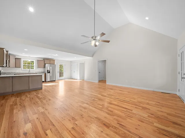 a view of an empty room with window and wooden floor