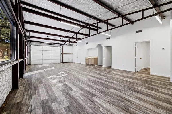 a view of a big room with wooden floor and a window