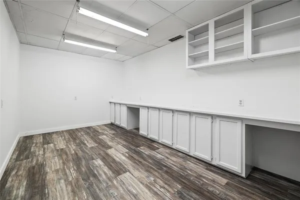 a view of an empty room with wooden floor