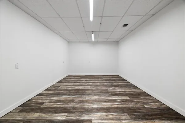 a view of empty room with wooden floor