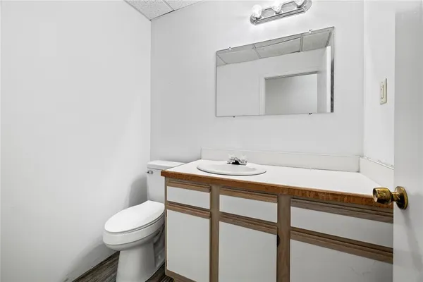 a bathroom with a toilet sink and mirror