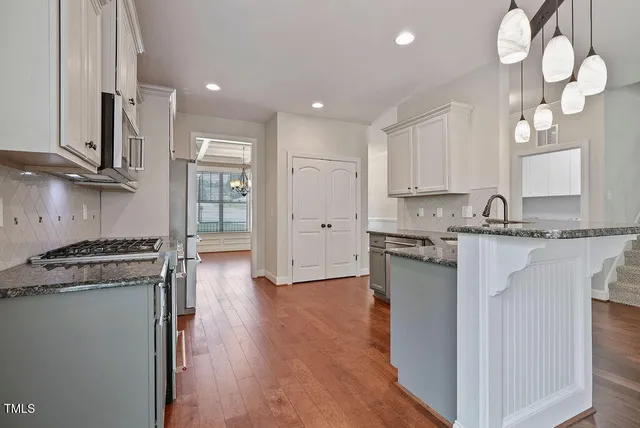 a kitchen with stainless steel appliances granite countertop a stove a sink and a refrigerator