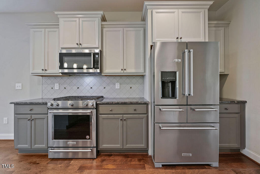 1124 Armsleigh Court Raleigh, NC 27603 - Photo 12 of 33 a kitchen with stainless steel appliances granite countertop a refrigerator stove and white cabinets
