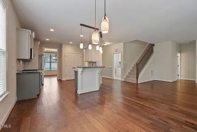 a view of a kitchen with cabinets and wooden floor