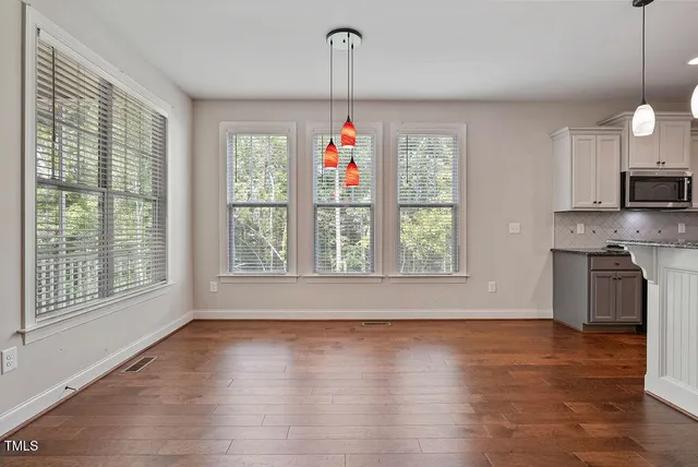 a very nice looking kitchen with wooden floor and a window