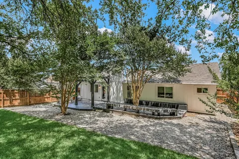 a backyard of a house with table and chairs