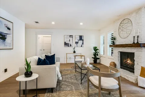 a living room with furniture a fireplace and a large mirror