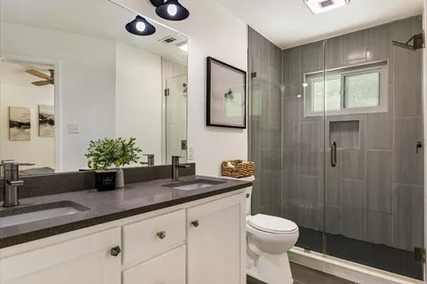 a bathroom with a sink a toilet and shower