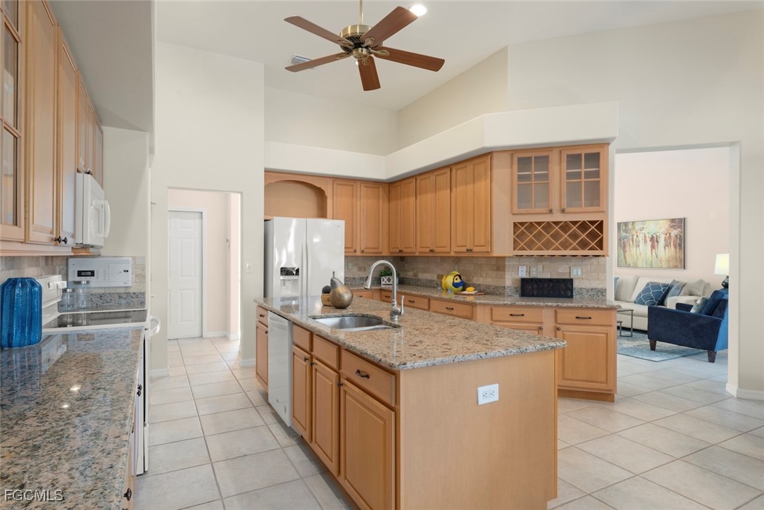23180 Whispering Ridge Drive Estero, FL 34135 - Photo 12 of 42 a kitchen with stainless steel appliances granite countertop a stove a sink dishwasher and a refrigerator with white cabinets