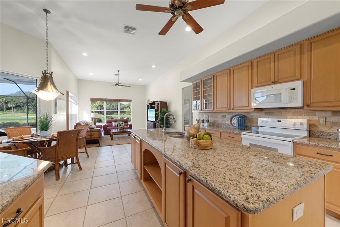 23180 Whispering Ridge Drive Estero, FL 34135 - Photo 14 of 42 a kitchen with sink stove and cabinets