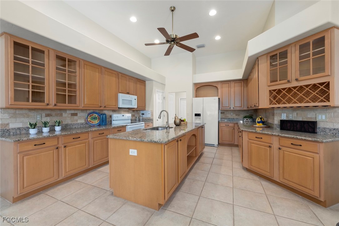 23180 Whispering Ridge Drive Estero, FL 34135 - Photo 15 of 42 a kitchen with stainless steel appliances granite countertop a sink and cabinets