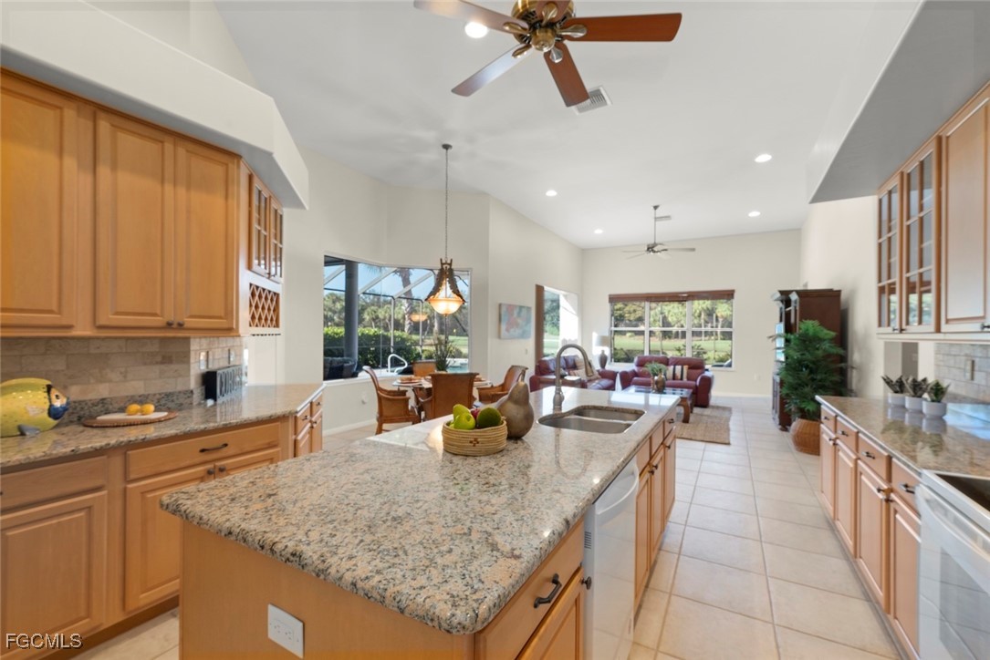 23180 Whispering Ridge Drive Estero, FL 34135 - Photo 16 of 42 a kitchen with stainless steel appliances granite countertop sink stove and cabinets
