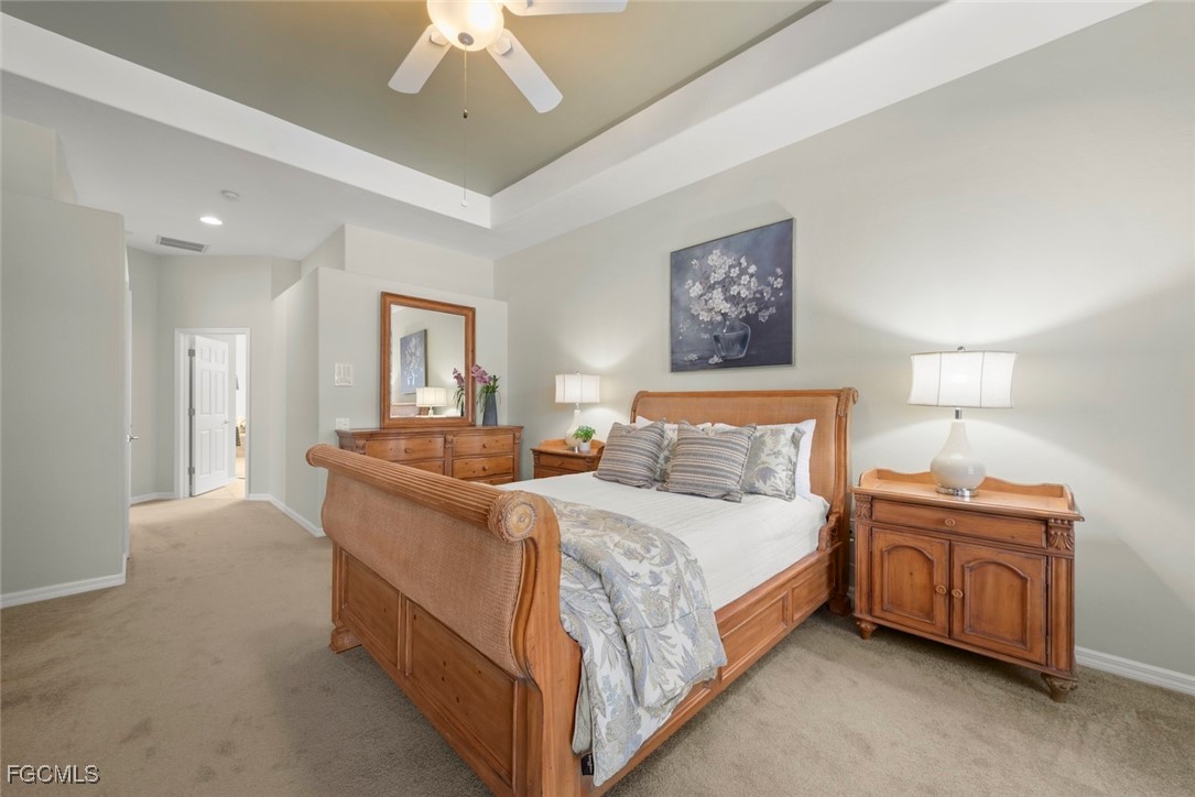 23180 Whispering Ridge Drive Estero, FL 34135 - Photo 23 of 42 a bedroom with a bed and a chandelier