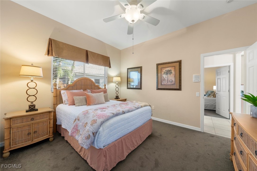 23180 Whispering Ridge Drive Estero, FL 34135 - Photo 27 of 42 a bedroom with a bed and a chandelier