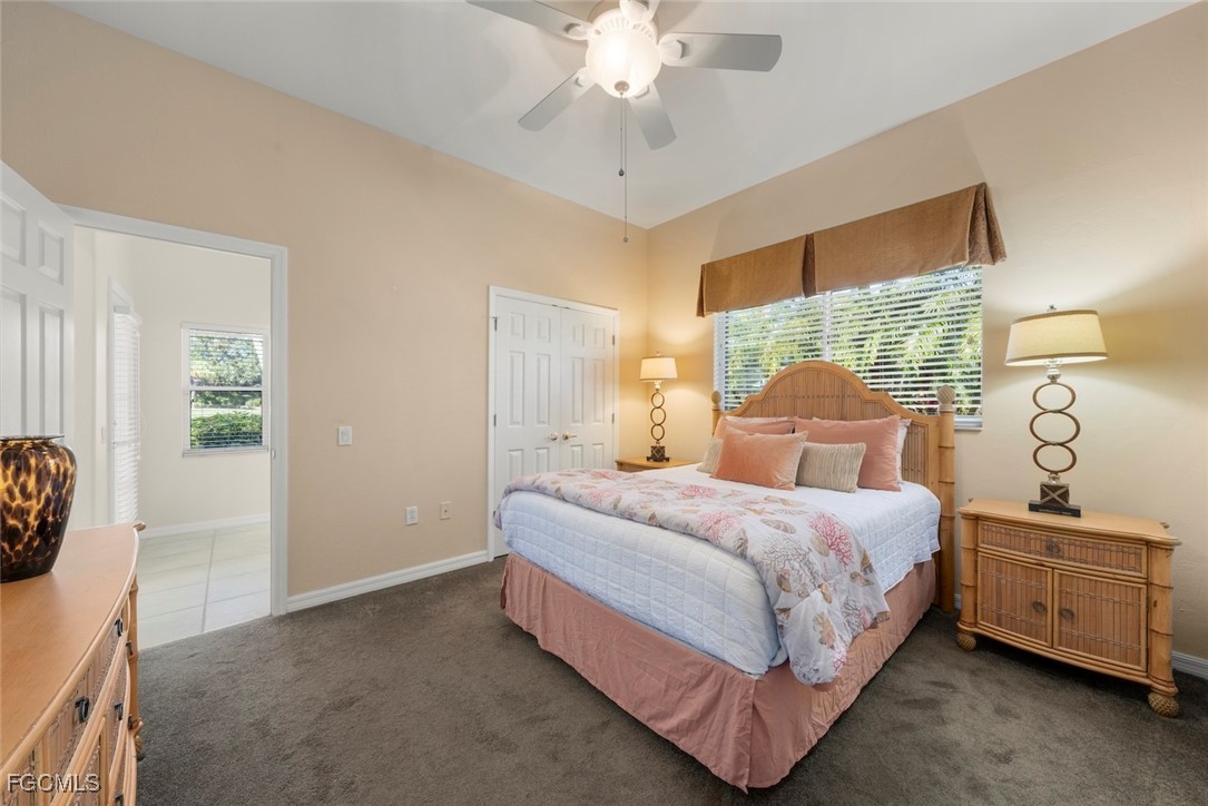 23180 Whispering Ridge Drive Estero, FL 34135 - Photo 28 of 42 a bedroom with a bed and a chandelier