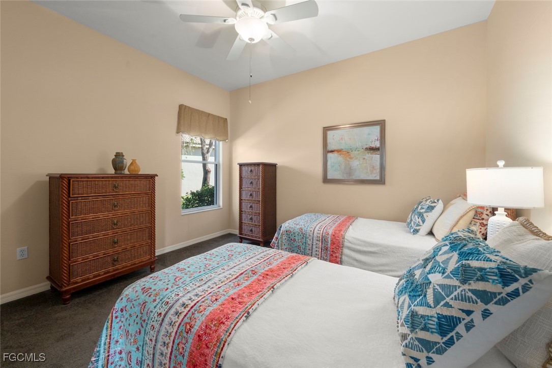 23180 Whispering Ridge Drive Estero, FL 34135 - Photo 30 of 42 a bedroom with a bed and a chandelier