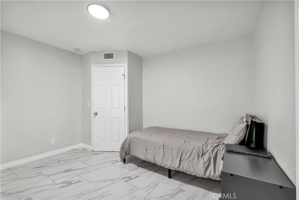 35716 Wildwood Canyon Road Yucaipa, CA 92399 - Photo 34 of 57 a bedroom with a bed and wooden floor