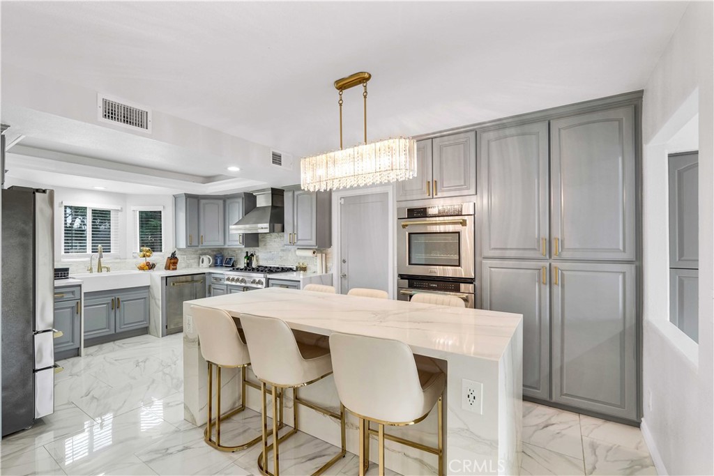 35716 Wildwood Canyon Road Yucaipa, CA 92399 - Photo 10 of 57 a kitchen with kitchen island a stove a chandelier and a refrigerator