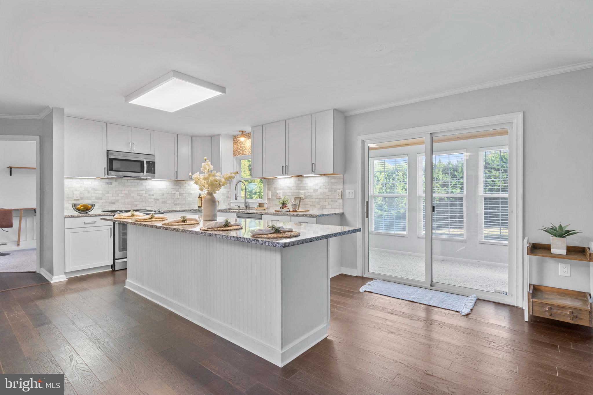 3446 Chaneyville Road Owings, MD 20736 - Photo 21 of 74 a kitchen with stainless steel appliances granite countertop a sink stove and wooden floor